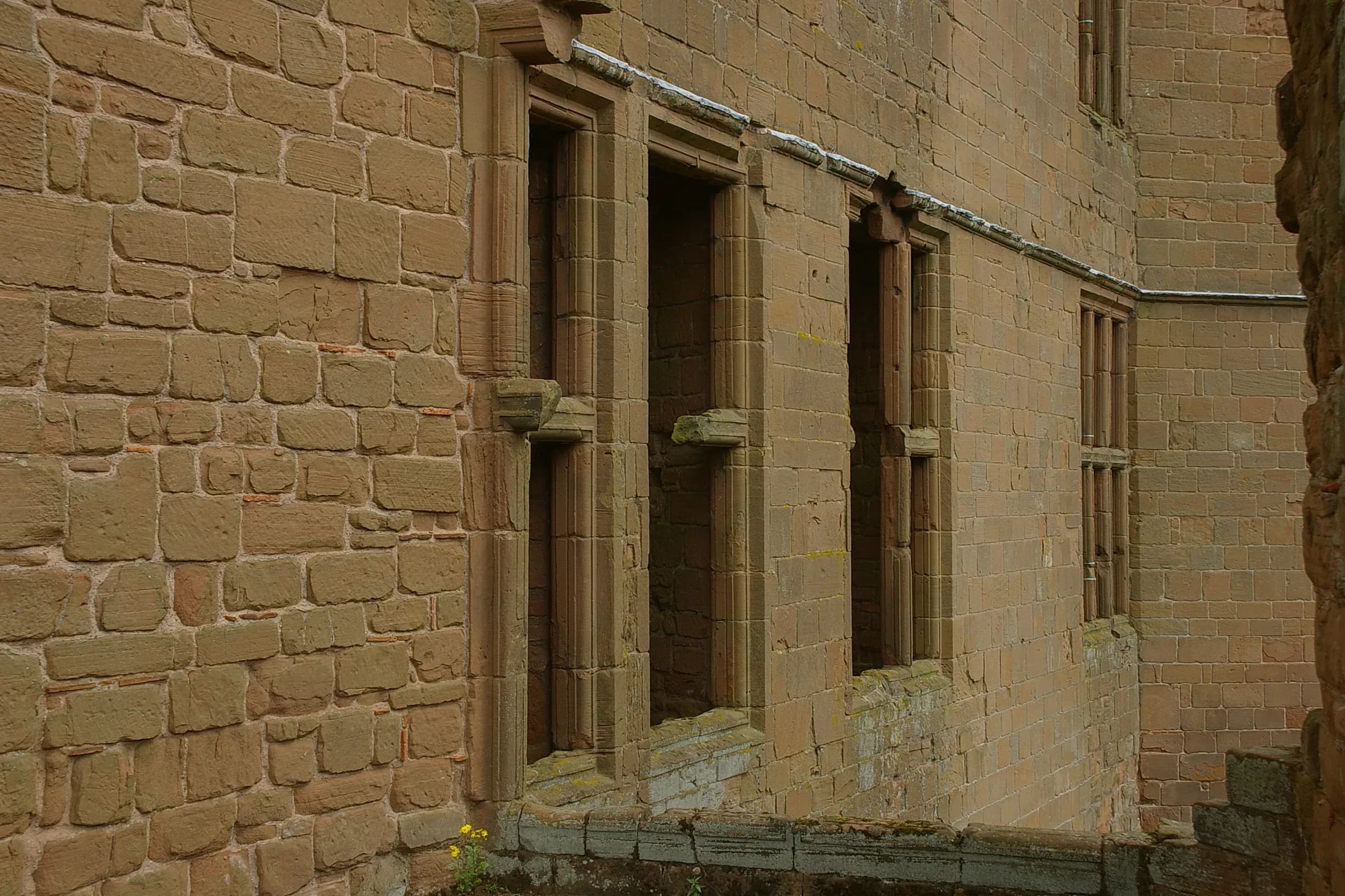The red sandstone ruins of Kenilworth Castle above its grassy earthworks.