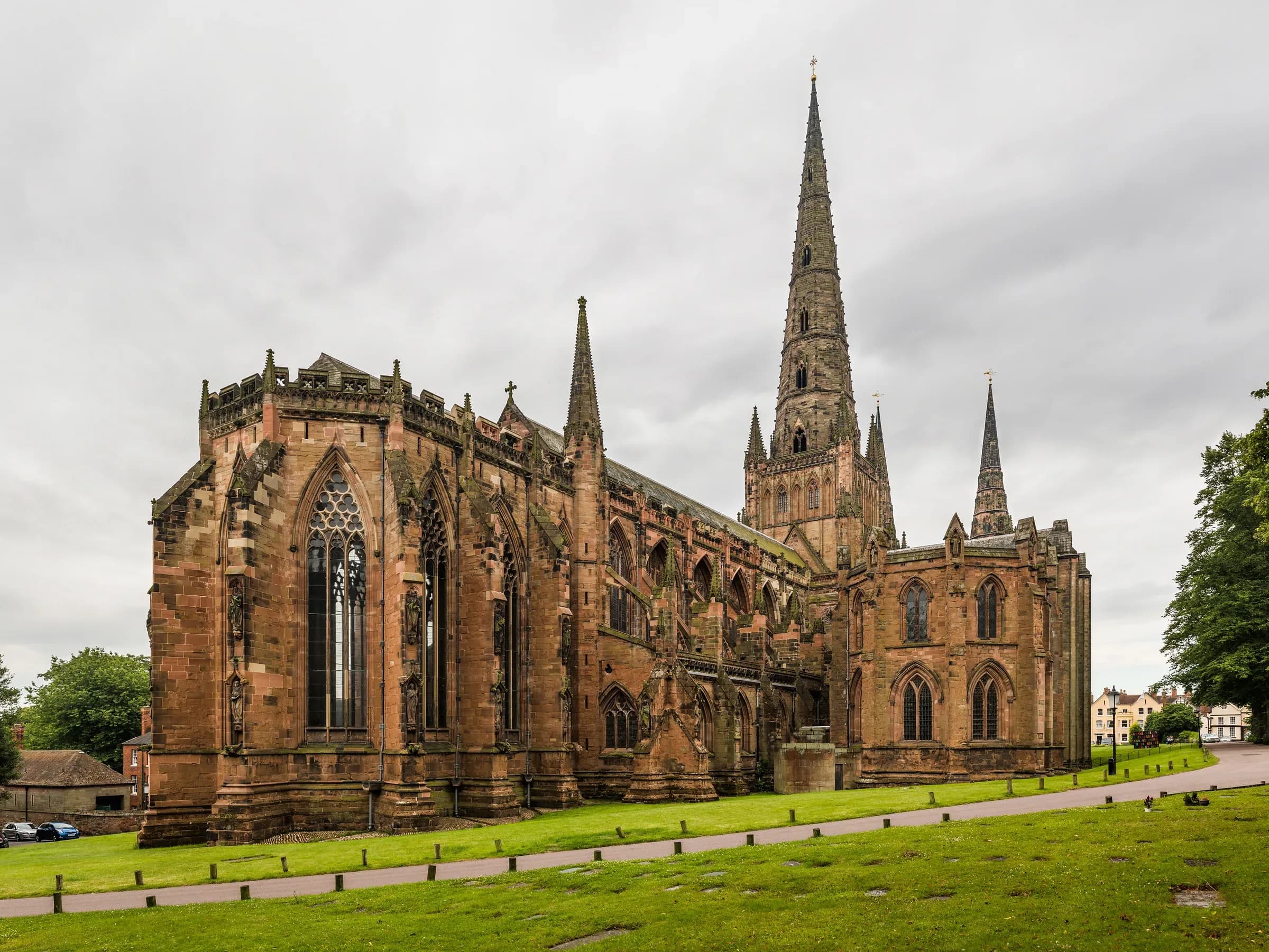 Lichfield Cathedral seen from the north east, its three spires above the surrounding trees.