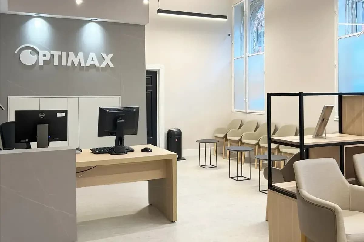 The reception desk and waiting area inside the Optimax clinic on Albert Square, Manchester, with the Optimax name on the wall behind.